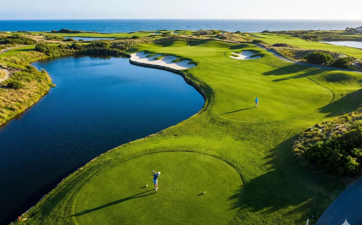A tee box beside a lake on a sunny course, the artwork for Range Rally Classic.